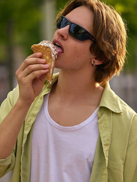 istock Young man enjoying ice cream cone outdoors on sunny day 2223549951