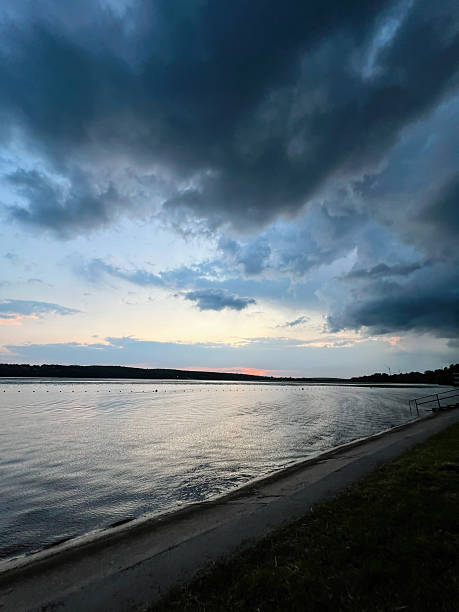 istock Dramatic sunset sky over calm river reflecting water with peaceful surroundings 2223550263