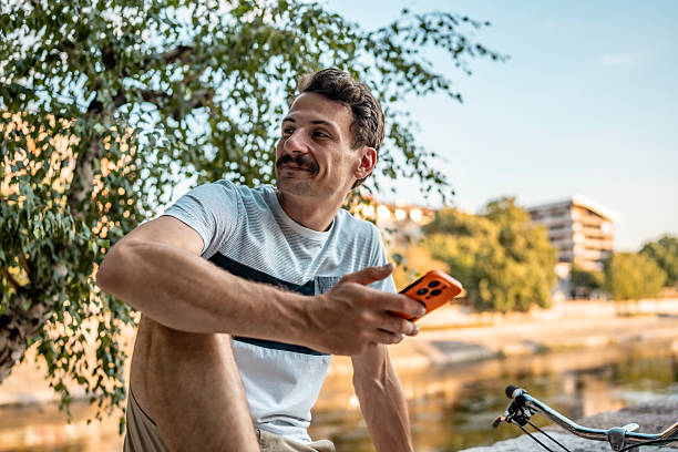 istock Man Relaxing Outdoors With Smartphone on a Sunny Day 2223551173