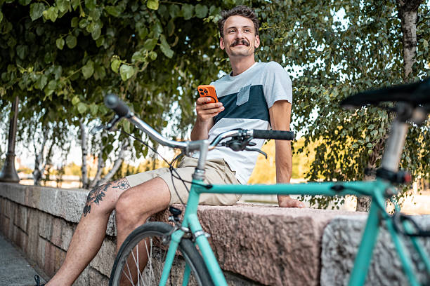 istock Man Relaxing Outdoors with Bicycle and Smartphone in Nature 2223551196
