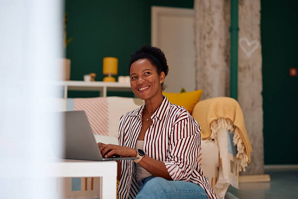 istock Smiling mid adult woman working from home using laptop 2223554384