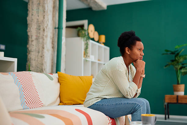 istock Pensive young woman reflecting while sitting on sofa at home 2223554488