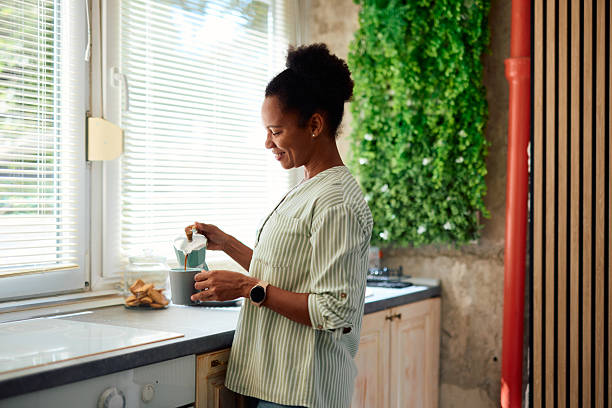 istock Woman pouring coffee in a mug in her modern kitchen 2223554605