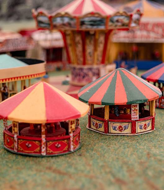 Miniature vintage carousel models with colorful canopies in a nostalgic fair setting.