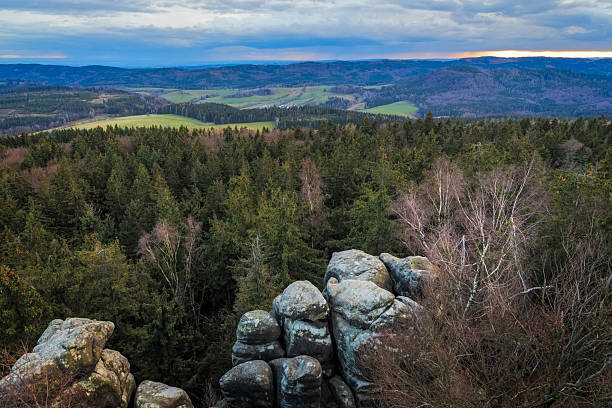 Panoramic landscape from Broumov Walls rock formations overlooking a valley with green fields and forests, Czech Republic