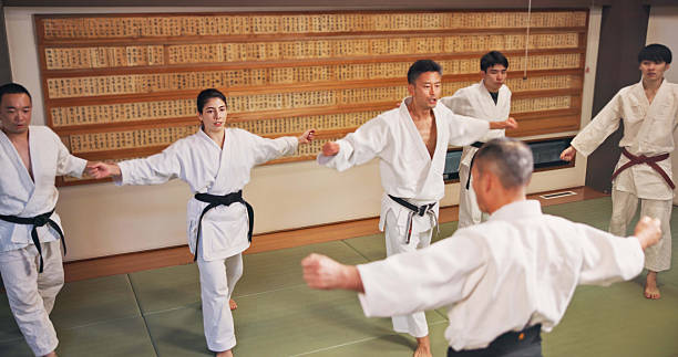 istock Martial arts, master and Japanese people with learning, exercise and karate etiquette in dojo. Japan, combat training and fight studio with sport, discipline and warrior in taekwondo class in gym 2223560319