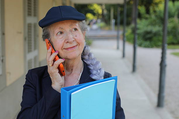 Smiling old lady communicating through mobile phone