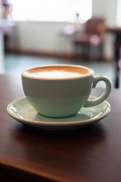 istock Cup of coffee with latte art on wooden table with soft sunlight. 2223562984
