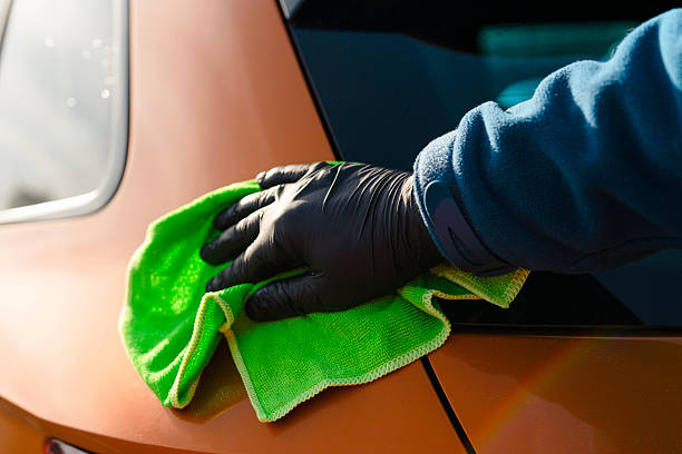 istock Applying liquid ceramic coating to vibrant orange car panel to protect it from scratches, chips and ultraviolet damage. Applying nano coating for long lasting car paintwork 2223564520