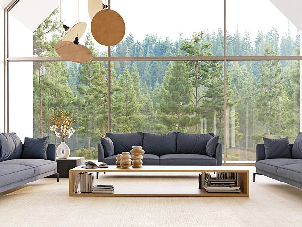 istock Modern living room with large window overlooking forest. Minimalist interior design with blue sofa. Bright space for relaxation. 2223567578