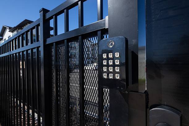 istock gate security  key pad on black door and fence 2223568602
