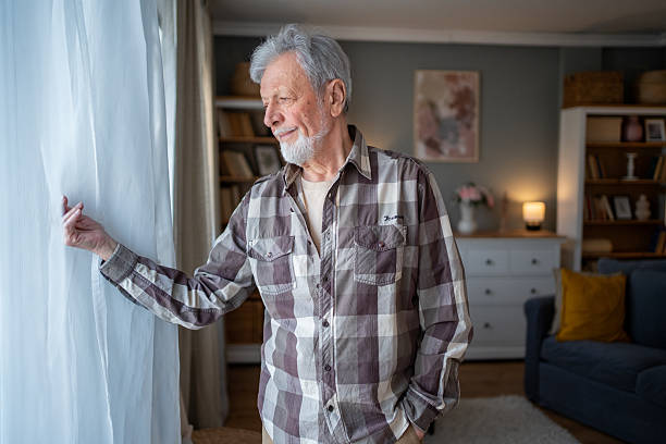 istock Senior man looking out the window in thoughtful contemplation 2223577116