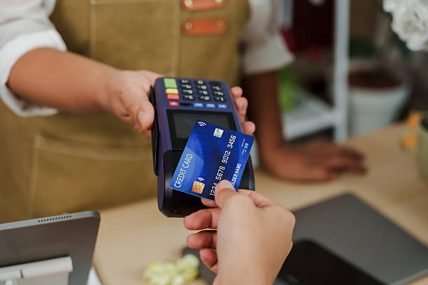 istock Customer holding credit card inserting into payment terminal held by asian senior florist inside flower store representing contactless cashless transaction for small flower business 2223586867
