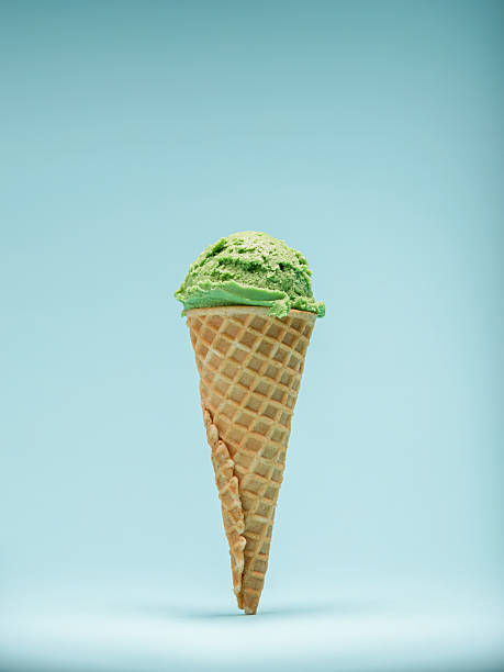 istock Green mint ice cream cone, isolated on a pale blue background 2223592838