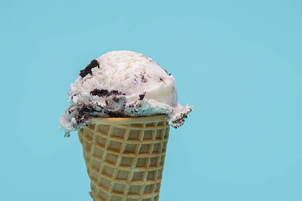 istock Cookies and cream ice cream cone, isolated on a light blue background 2223592839