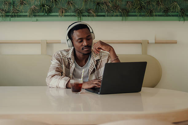 istock Focused freelancer working on laptop in modern cafe with headphones 2223593553