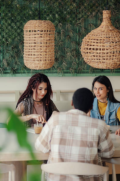 istock Young adults enjoying coffee and conversation in a trendy cafe 2223594780