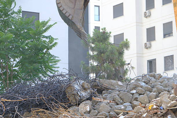 A building demolition site where work is carried out by many people and machines such as power shovels.