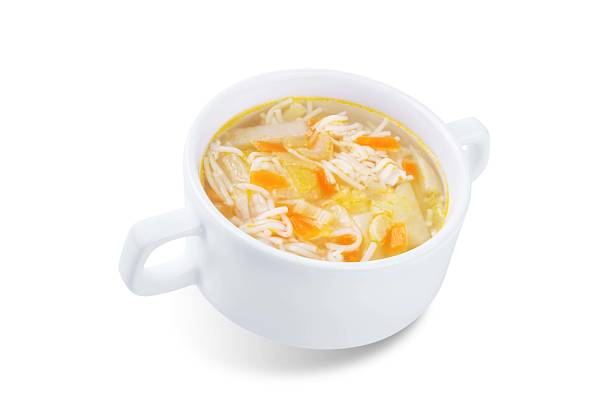 Potato pasta celery chicken soup in a bowl on a white isolated background. toning