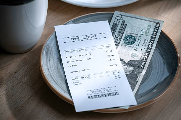 istock Paying restaurant bill with cash on a plate with receipt 2223604555