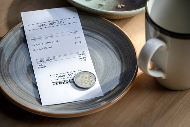 istock Cafe receipt with euro coins and empty coffee cup on table 2223604557