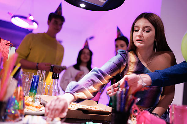 Group of young adults celebrating a gathering enjoying food and festive decorations