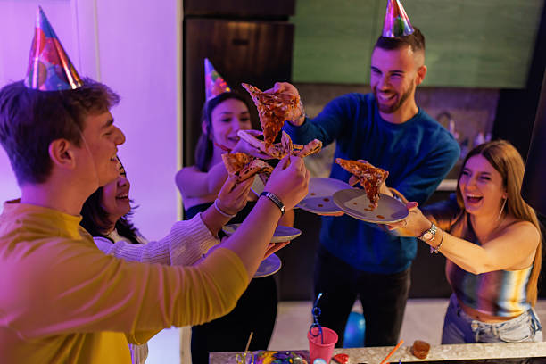 Friends Celebrating Together with Pizza and Snacks at a Party