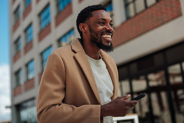 istock Young businessman smiling while using smartphone in the city 2223610634