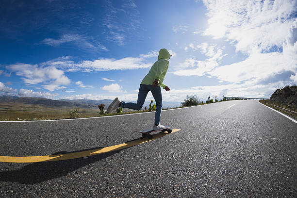Skateboarder skateboarding on the mountain road