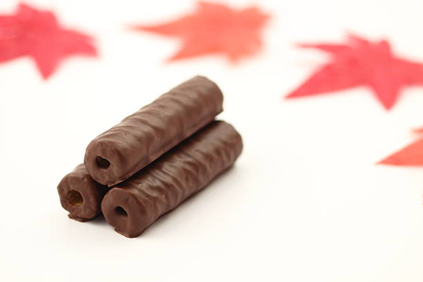 These chocolate sticks, neatly lined up on a white background, are eye-catching for their beautiful silhouette. Their elegant appearance creates a special time.