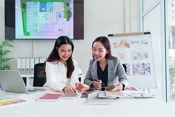 istock Asian Women Interior Designers Collaborating on Project with Swatches, Floor Plan Design and Creative Architecture Design for Home and Building 2223614376