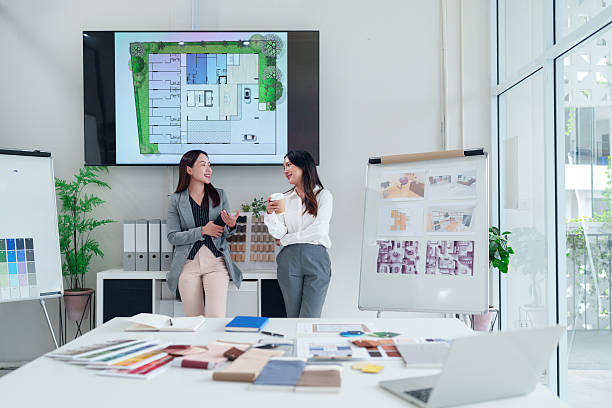 istock Asian Interior Designers Discussing House Plans with Modern Design Elements in a Bright Office Setting for Architecture and Renovation Projects 2223614403