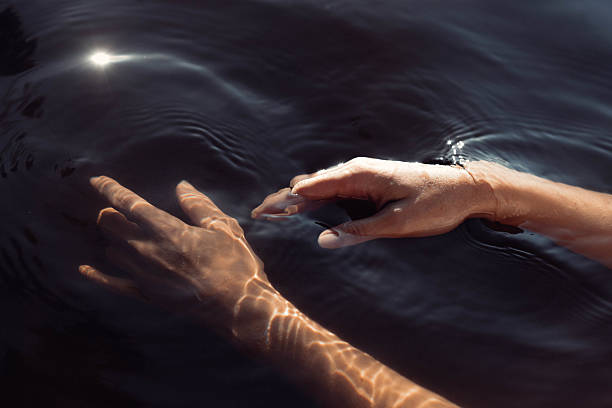istock Fingers reach out to touch emerald waters, creating soft ripples as sunlight dances on the surface, adding a serene touch to the peaceful lakeside atmosphere at midday 2223618342