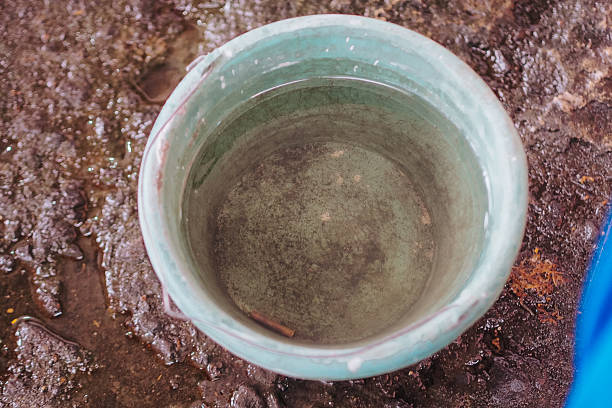 Buckets Filled with Rainwater on a Muddy Floor
