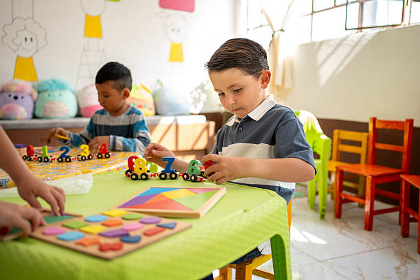 istock Children engaged in hands-on learning activities at a preschool classroom. Diverse group of boys playing with colorful number train and geometric puzzle. early math skills, and playful education 2223620993