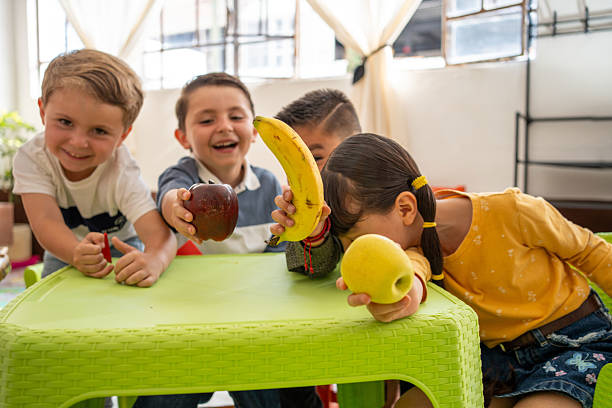 istock Kindergarten children proudly display fruits during a classroom preschool activity. Focus on healthy eating, nutrition education, and promoting good habits in a diverse learning environment. 2223621105