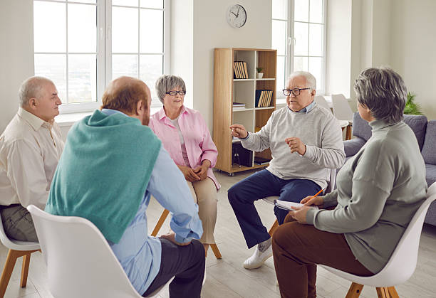 istock Group of elderly people talking on therapy session at nursing home discussing problems together. 2223622254