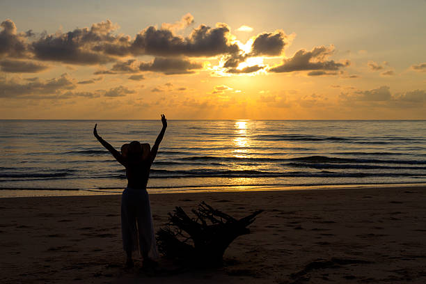 Woman relax with sunrise and silhouette at beach Bang Boet; Prachuap Khiri Khan Province in Thailand is famous for travel and relax.