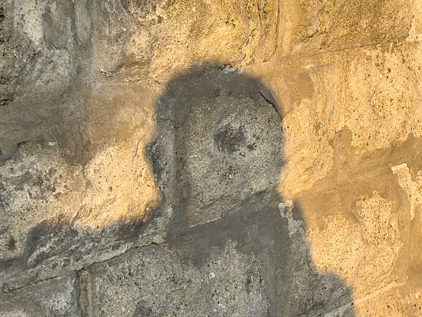 istock Silhouette of person's head on rustic stone wall in warm evening light 2223627614