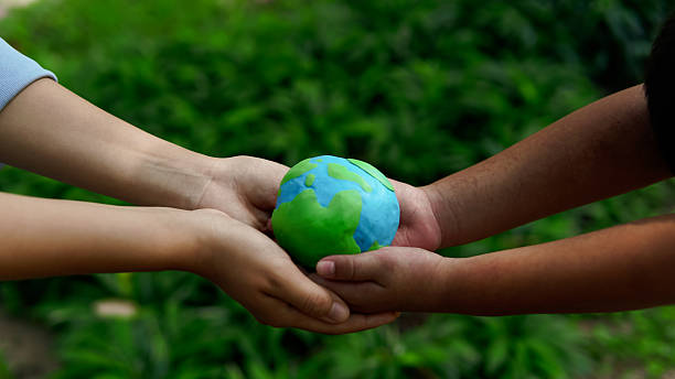 istock Hands holding green earth together on nature background for the Sustainable Development Goals. Responsibility for the environment.Global community teamwork. Ecosystem. Save world. 2223629310