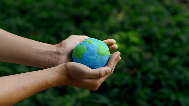 istock Hands holding green earth together on nature background for the Sustainable Development Goals. Responsibility for the environment.Global community teamwork. Ecosystem. Save world. 2223629369