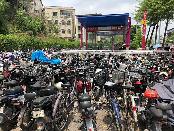 Guangzhou, Guangdong Province, China - April 22, 2025: Dozens of electric bicycles around a subway entrance in the Huangpu District, Guangzhou, riding a e-bike is a good way for the connection of the traffic.
