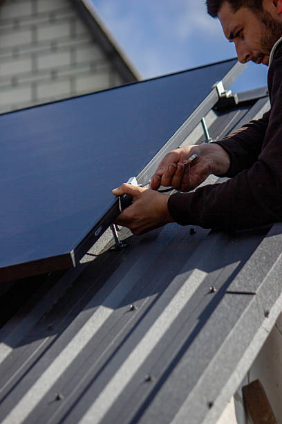 istock A man is installing solar panels on a roof. Selective focus 2223642189