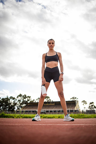 istock A focused female athlete captured during her training on the track, showcasing preparation, hydration, and determination in stadium setting. Highlights fitness, motivation, and athletic performance. 2223643360