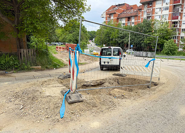 istock Roadside excavation area secured with barriers and a parked service van. Infrastructure maintenance in progress. 2223645591