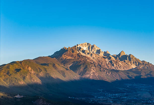 The landscape of Yulong Snow Mountain bathed in sunlight on golden mountains