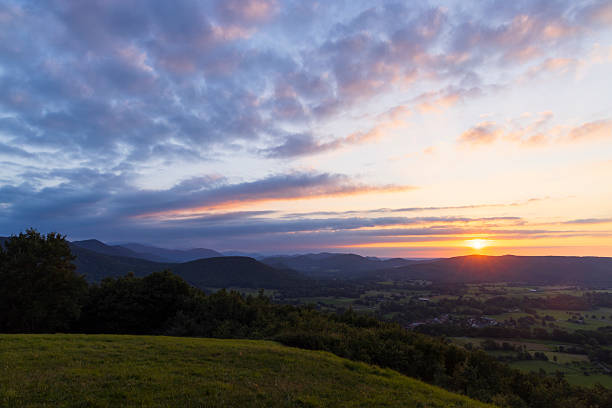 Vibrant sunset casting colorful hues over lush green landscape