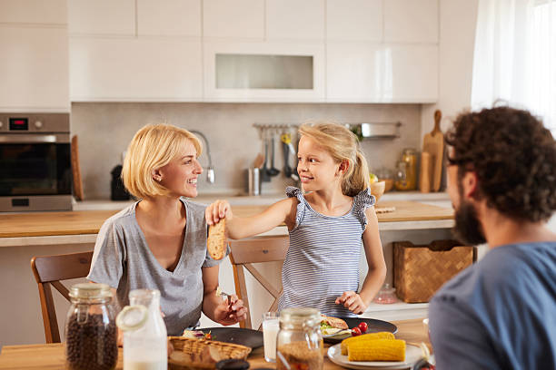 istock Happy family sharing bread during breakfast in kitchen 2223654989