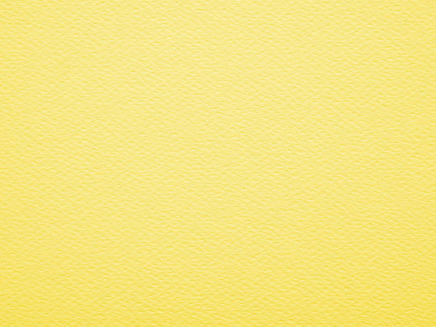 istock Close-up, straight-on shot of a solid, yellow paper has a visible, slightly rough texture with small, irregular fibers. Blank yellow paper background. 2223656539