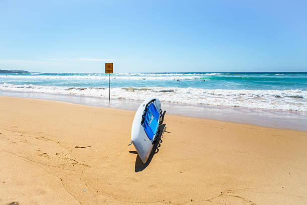 istock Paddleboard at a sandy beach and a sign warning of dangerous current 2223658010